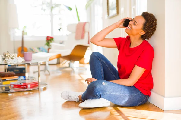 Beautiful young african american woman sitting on the floor havi — Stock Photo, Image