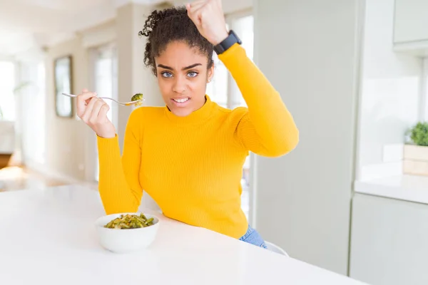 Young African American Woman Eating Healthy Green Vegatables Annoyed Frustrated — 스톡 사진