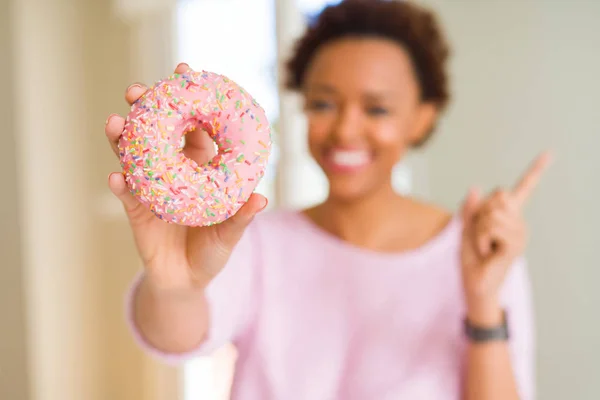 Joven Afroamericana Americana Comiendo Rosado Azúcar Donut Muy Feliz Señalando —  Fotos de Stock