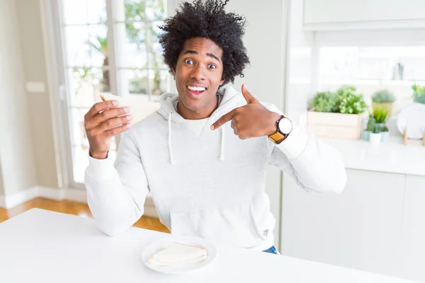 Αφρικανός Αμερικανός Άνθρωπος Τρώει Χειροποίητο Σάντουιτς Στο Σπίτι Έκπληξη Πρόσωπο — Φωτογραφία Αρχείου