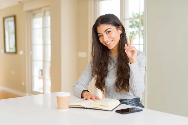 Mujer Joven Leyendo Libro Bebiendo Café Sorprendida Con Una Idea —  Fotos de Stock