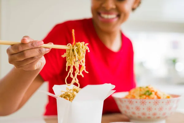 Linda jovem afro-americana comendo macarrão usando choo — Fotografia de Stock