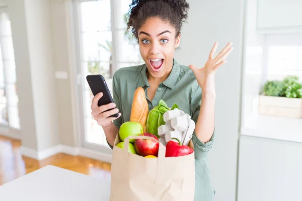Chica Afroamericana Joven Sosteniendo Bolsa Papel Comestibles Usando Teléfono Inteligente — Foto de Stock