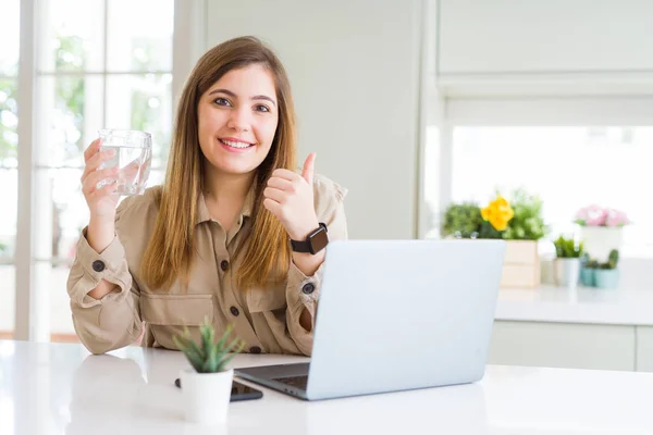 美丽的年轻女子与电脑工作休息喝杯水快乐与大微笑做Ok标志 拇指用手指 优秀的标志 — 图库照片