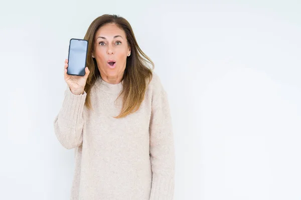 Frau Mittleren Alters Zeigt Smartphone Bildschirm Vor Isoliertem Hintergrund Erschrocken — Stockfoto