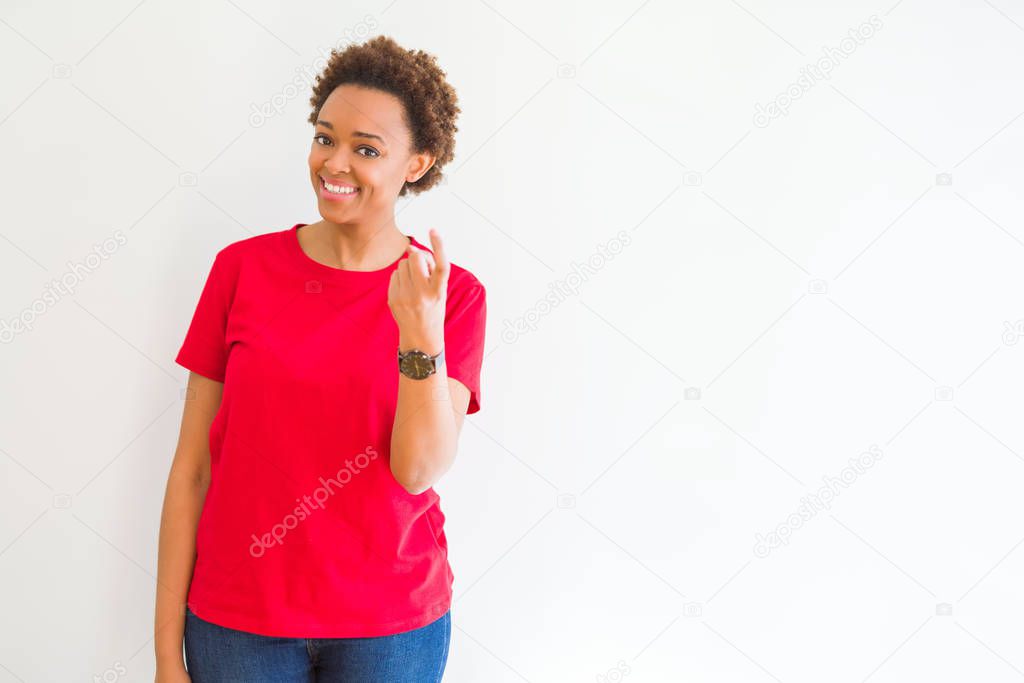 Young beautiful african american woman over white background Beckoning come here gesture with hand inviting happy and smiling