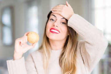 Evde taze patates tutan genç ve güzel bir kadın. Elleri başının üstünde, utanç ve şaşkınlık dolu, sinirli ve hayal kırıklığına uğramış bir şekilde. Hata için korku ve üzüntü.