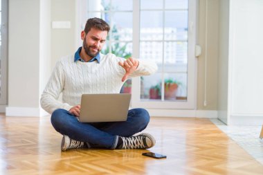 Yakışıklı adam giyen çalışma bilgisayar dizüstü kullanarak kızgın yüzü, eksi işareti aşağı antipati başparmak ile gösterilen, ret kavramı ile