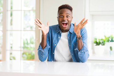 Yakışıklı afro-amerikan adam evde deli kutluyor ve kollarını kaldırdı ve açık gözleri heyecan çığlık ile başarı için hayran. Kazanan kavramı