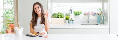 Güzel bir kadının teslimattan Asya suşisi yerken, kameraya bakıp zafer işareti yaparken gülümsediği geniş açılı bir görüntü. İki numara..