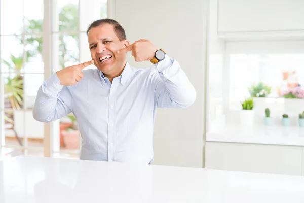 Hombre Mediana Edad Sentado Casa Sonriendo Confiado Mostrando Señalando Con — Foto de Stock