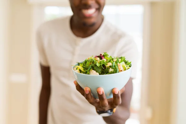 Afrikaanse jonge man met een kom gezonde salade glimlachend cheerf — Stockfoto