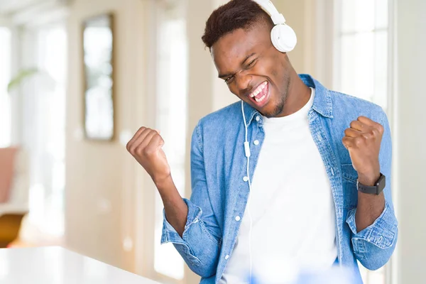 Hombre Afroamericano Con Auriculares Escuchando Música Celebrando Sorprendido Sorprendido Por —  Fotos de Stock