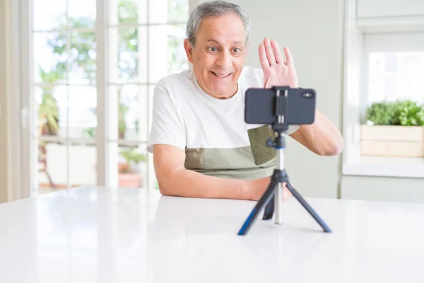 Gutaussehender älterer Mann winkt der Smartphone-Kamera zu — Stockfoto
