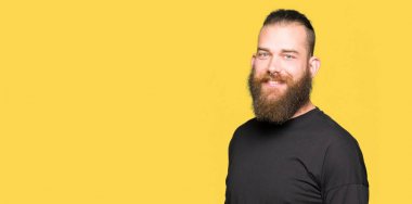 Genç Sarışın yüzünde mutlu ve güzel bir gülümseme ile rahat t-shirt giyen adam. Şanslı kişi.