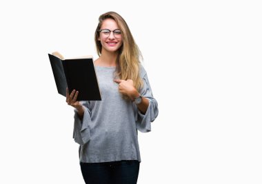 Genç güzel sarışın kadın kendisine sürpriz yüz işaret parmağı izole arka plan üzerine bir kitap okuma