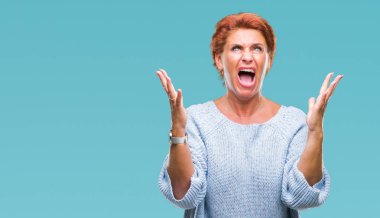 Üzerinde kış kazak giyen Atrractive üst düzey beyaz Kızıl saçlı kadın arka plan deli izole ve deli bağırarak ve agresif ifade ve silah kaldırdı bağırıyor. Hayal kırıklığı kavramı.