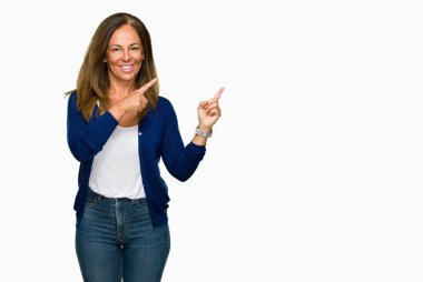 Gülümseyen ve iki elleri ve parmakları ile tarafına işaret kamera bakarak izole arka plan güzel orta yaş rahat yetişkin kadın.