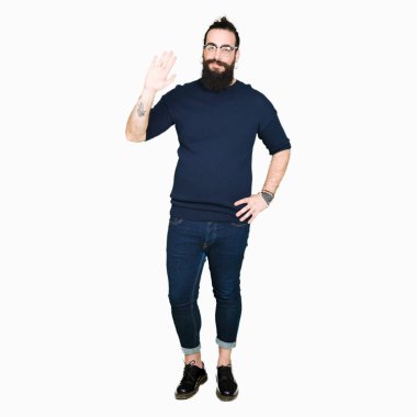 Genç hipster uzun saç ve sakal gözlük ile Waiving mutlu Merhaba dostum ve gülümseyen, dostça jest hoş geldiniz