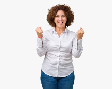 Güzel orta ager üst düzey businees kadın kutluyor izole arka plan üzerinde şaşırttı ve başarı için kaldırdı kollarını açarak hayret ve gözleri açık. Kazanan kavramı.