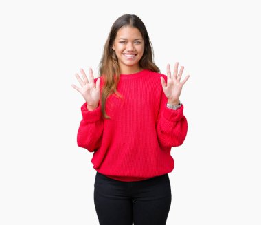 Gösterilen ve parmakları ile işaret izole arka plan üzerinde kırmızı kış kazak giyen genç güzel esmer kadın kendinden emin ve mutlu gülümseyerek süre on numara.