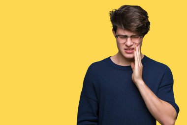 Diş ağrısı veya dişlerde dişlerle ilgili hastalık nedeniyle ağız acı ifadesi ile el ile dokunmak izole arka plan üzerinde gözlük takan yakışıklı delikanlı. Diş hekimi kavramı.