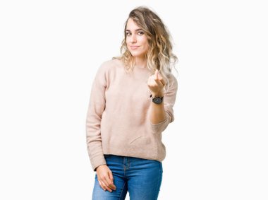 Beckoning gel burada mutlu ve gülümseyerek el davet ile jest arka plan üzerinde sweatershirt giyen genç güzel sarışın kadın izole