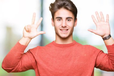 Yakışıklı delikanlı gösterilen ve parmakları ile işaret izole arka plan üzerinde kendinden emin ve mutlu gülümseyerek süre sekiz numara.