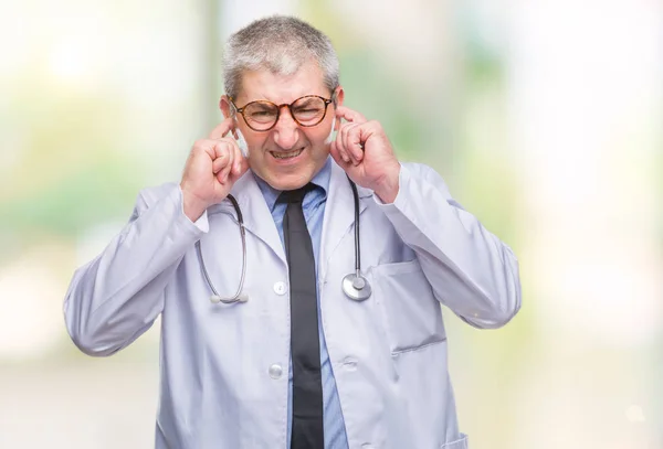 Guapo Médico Senior Sobre Fondo Aislado Cubriendo Las Orejas Con —  Fotos de Stock