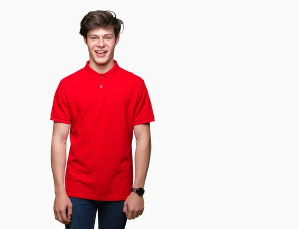 顔に幸せでクールな笑顔で孤立した背景の上に赤い シャツを着て若いハンサム男 幸運な人 — ストック写真