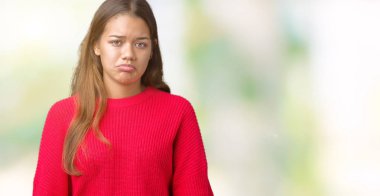 İzole arka plan üzerinde kırmızı kış kazak giyen genç güzel esmer kadın depresif ve kızgın ve korkmuş ağlıyor sıkıntı için endişeleniyorum. Üzgün ifade.