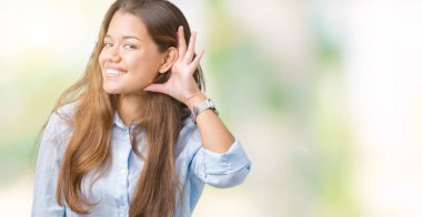 Genç güzel esmer iş kadını bir işitme söylenti ya da dedikodu için dinleme kulak üzerinde el ile gülümseyen izole arka plan üzerinde. Sağırlık kavramı.