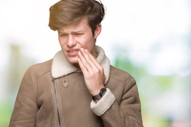 Diş ağrısı veya dişlerde dişlerle ilgili hastalık nedeniyle ağız acı ifadesi ile el ile dokunmak izole arka plan üzerinde kış ceket giymiş yakışıklı delikanlı. Diş hekimi kavramı.