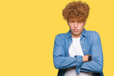 Yakışıklı genç afro saçlı kot ceket şüpheci ve sinir, onaylamayan ifade yüz çapraz kollu giyiyor. Negatif kişi.