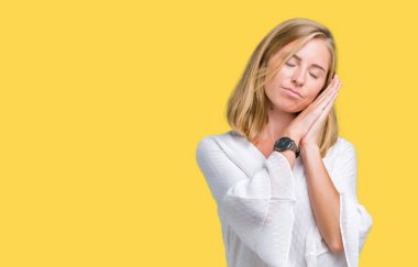 Uyku yorgun hayal ve ellerle birlikte poz ile kapalı gözler gülümseyen izole arka plan güzel genç zarif kadın.