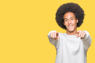Sportif sweatshirt giyen afro saçlı genç Afro-Amerikan adam sen ve kameraya gülümseyen pozitif ve neşeli parmaklarıyla işaret