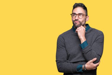 Çene düşünme hakkında soru, dalgın ifade üzerine el ile izole arka plan üzerinde gözlük takan yakışıklı delikanlı. Düşünceli yüzüyle gülümsüyor. Şüphe kavramı.