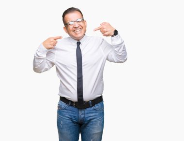 Orta yaş bussines Arap adam kendinden emin gösterilen ve işaret parmakları diş ve ağız ile gülümseyen izole arka plan üzerinde gözlük takıyorum. Sağlık kavramı.