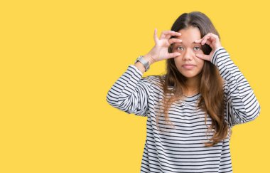 Parmaklarıyla, Uykulu ve sabah yorgunluk için yorgun gözlerini açmaya çalışırken izole arka plan üzerinde çizgili süveter giyen genç güzel esmer kadın