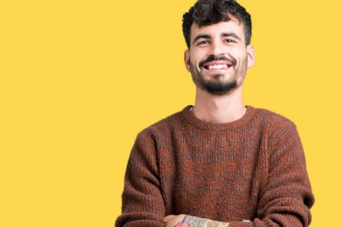 Mutlu yüz ile gülümseyerek kameraya seyir silah geçti arka plan üzerinde kış kazak giyen genç yakışıklı adam izole. Olumlu bir kişi.