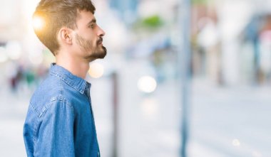 Yakışıklı delikanlı izole arka tarafına, seyir üzerinde dinlenmek doğal yüz emin gülümseme ile pozuyla profili.