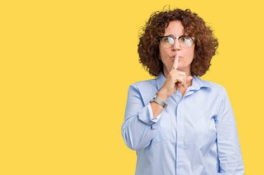 Güzel orta ager üst düzey businees kadın dudaklarında parmak ile sessiz olmanı izole arka plan üzerinde gözlük takıyorum. Sessizlik ve gizli kavramı.
