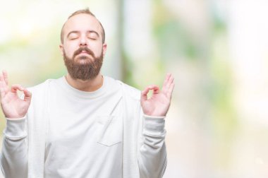 Genç beyaz hipster adam giyiyor spor giyim izole arka plan üzerinde dinlenmek ve gülümseyen gözlerle kapalı parmak jestle meditasyon yapıyor. Yoga kavramı.