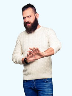 Kışlık kazak giyen genç hipster adam iğrendi ifade, hoşnutsuz ve korkulu tiksinti yüz yapıyor çünkü nefret tepki. Elleri havada. Sinir bozucu kavram.