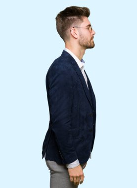 Güneş gözlüğü ve yan için arıyorum moda ceket giyen genç yakışıklı zarif adam sakin ol kendine güvenen gülümseme ile doğal yüz pozuyla profili.