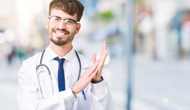 Genç doktor adam giyen hastane kat izole üzerinde arka plan Clapping ve mutlu ve neşeli, gururlu gülümseyen birlikte eller alkış