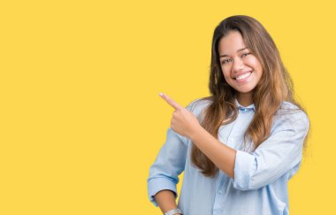 Genç güzel esmer iş kadını izole arka neşeli bir gülümseme ile el ve parmak kadar yan yüzünde mutlu ve doğal ifade ile işaret yüz üzerinden