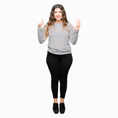 Kendinden emin ve mutlu gülümseyerek süre yedi numara gösterilen ve parmakları ile işaret genç güzel kadın giyiyor çizgili süveter.