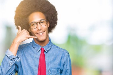 Gözlük ve kırmızı kravat yapıyor gülümseyen afro saçlı genç Afro-Amerikalı iş adamı telefon hareketi ile el ve parmak telefonda konuşuyor gibi. Kavramları iletişim.