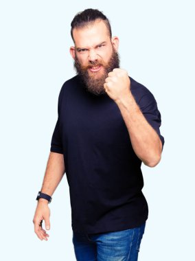 Genç sarışın adam rahat t-shirt giyen kızgın ve deli yükselterek yumruk sinirli ve öfkeli öfke ile bağırırken. Öfke ve agresif kavram.
